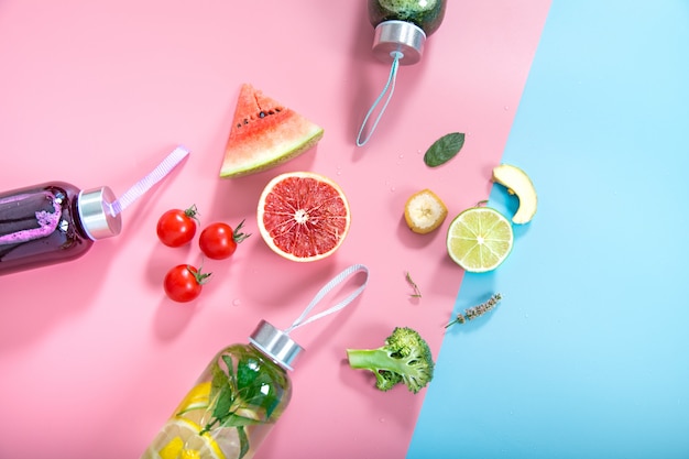 Free photo glass bottles with natural drinks on a colored wall