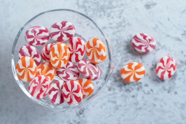 Free Photo glass bowl full of colorful round milk candies on stone background. high quality photo