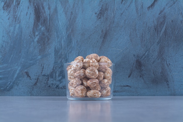 A glass bowl full of healthy cereals on gray table. 