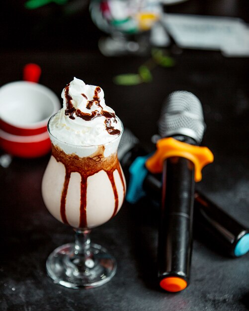 Free photo a glass of cacao cocktail with chocolate syrup and whipped cream