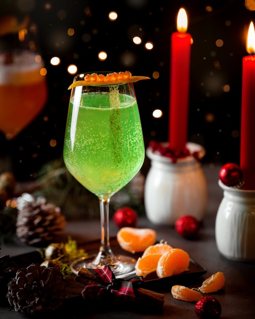 A glass of carbonated green drink and mandarin