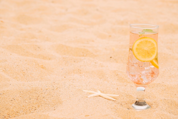 Glass of chilling drink with sliced citrus and starfish