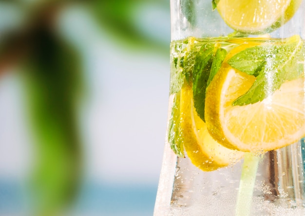 Glass of chilling drink with sliced lime and mint leaves