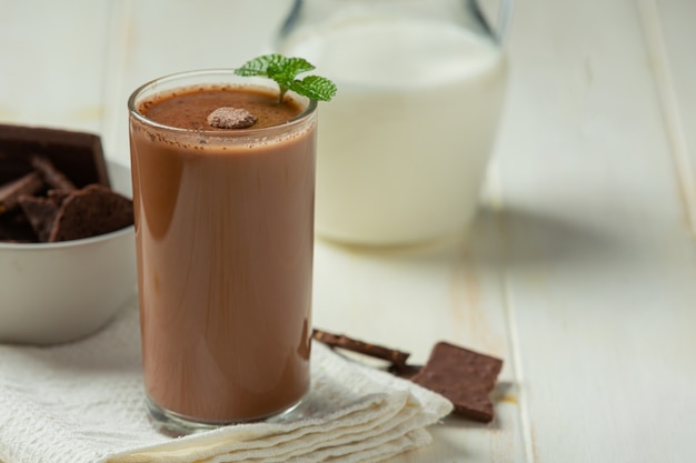 Glass of chocolate milk on the dark surface.