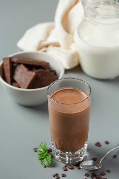 Glass of chocolate milk on the dark surface.