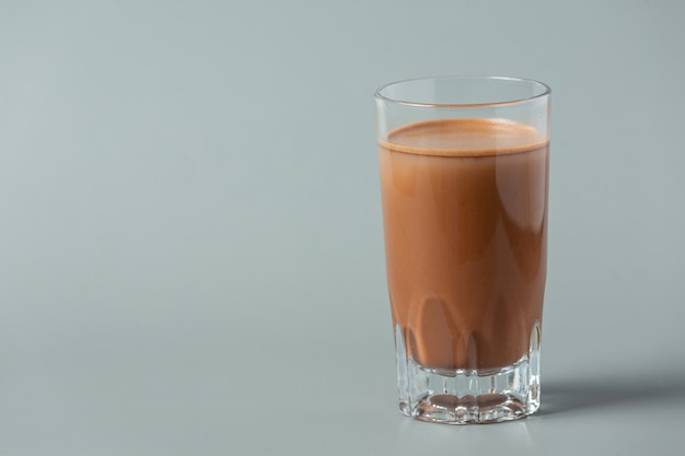 Glass of chocolate milk on the dark surface.