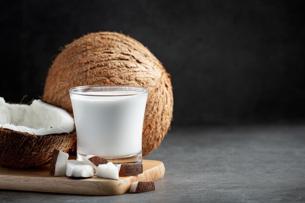 glass of coconut milk put on wooden cutting board