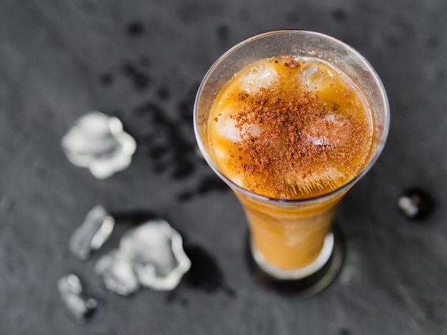 Free photo glass of coffee cocktail with ice cubes and powder