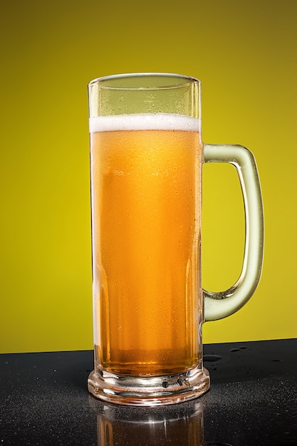 Free photo glass of cold frothy lager beer on an old wooden table