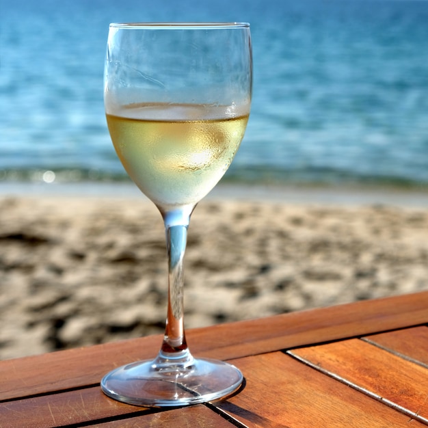 Free photo glass cold white wine mediterranean beach table square