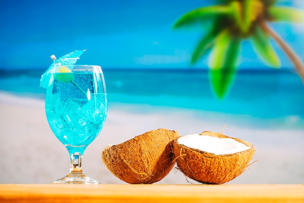 Free photo glass of cooling blue drink and cracked coconuts