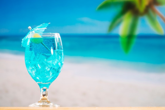 Free photo glass of cooling blue drink decorated with olive and umbrella