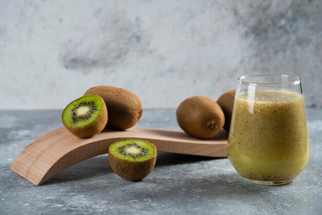 A glass cup of delicious kiwi juice on marble. 