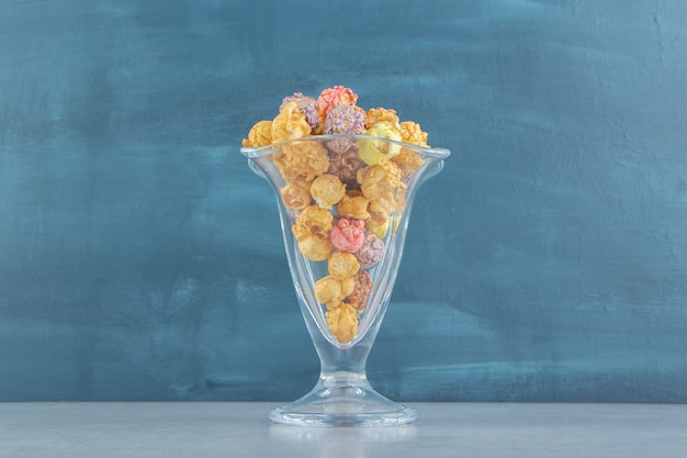 Free photo a glass cup of sweet multicolored popcorn .