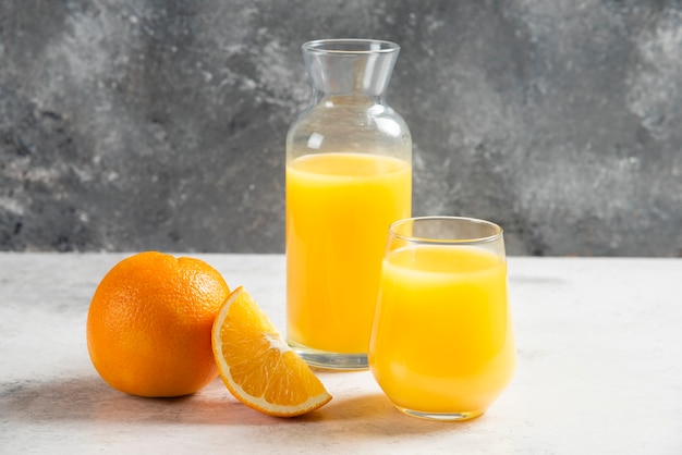 A glass cups of fresh juice with slices of orange.