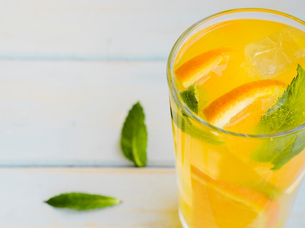 Free Photo glass of dewy orange juice with slices and mint