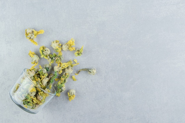 Free Photo glass of dry chrysanthemum flowers on stone table. 