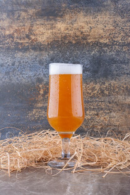 Glass of foamy beer on marble table. High quality photo