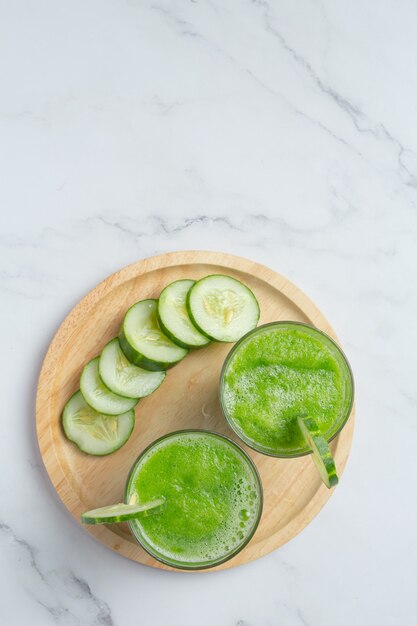 Glass of fresh cucumber juice on marble background