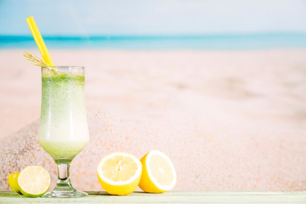 Glass of fresh green smoothie and sliced citrus 