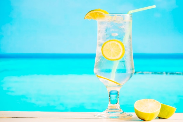 Free photo glass of fresh lemon drink with straw and sliced lime