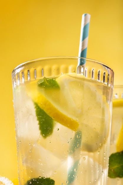 Free photo glass of fresh lemonade on yellow background