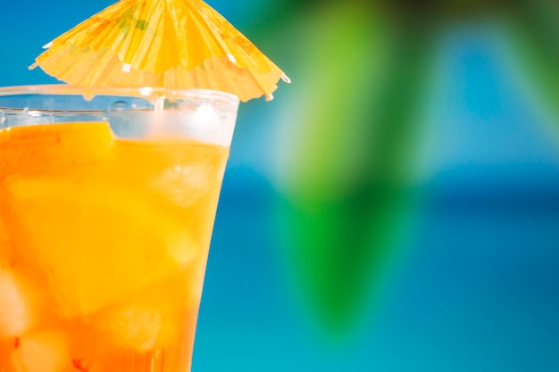 Free Photo glass of fresh orange drink decorated with bright umbrella 