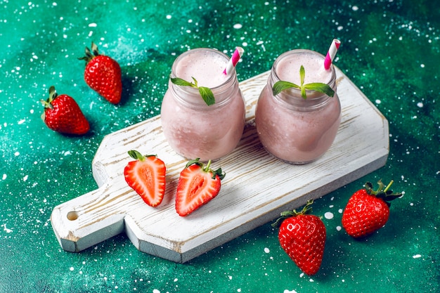 Glass of fresh strawberry milkshake, smoothie and fresh strawberries,healthy food and drink concept.