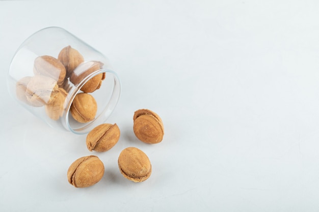 A glass jar full of sweet walnut shaped cookies.