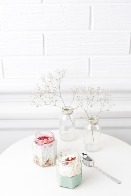 Glass jar smoothies and baby breathes flower in vase on white table