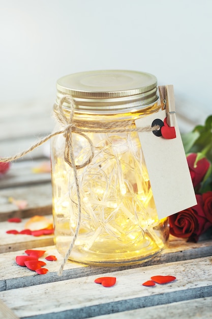 Free photo glass jar with lights on and a letter tied with a rope