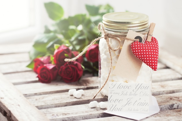 Glass jar with marshmallows and a heart with a forceps