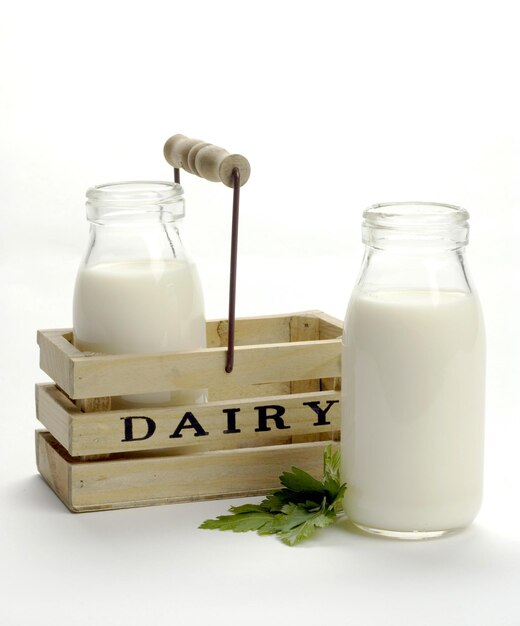 Glass jars with fresh milk with a wooden box