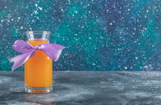 Free Photo glass of orange juice on marble table.