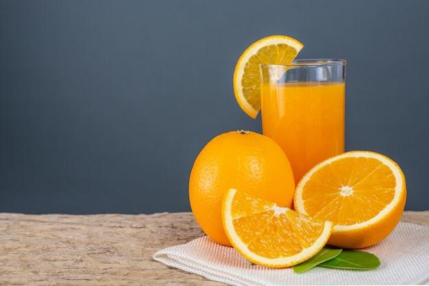 Glass of orange juice placed on wood.