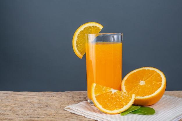 Glass of orange juice placed on wood.