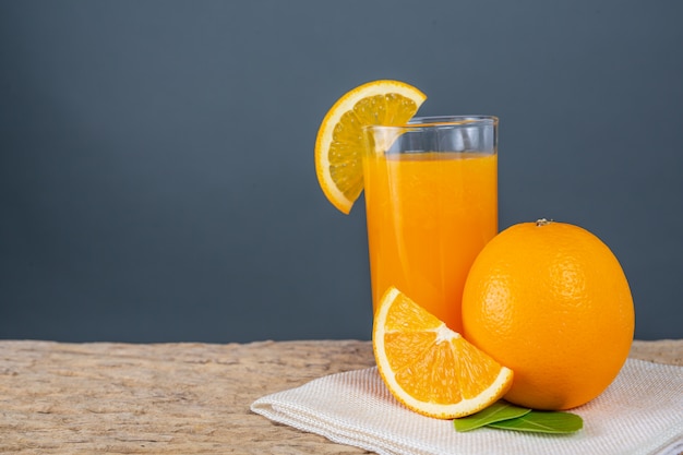 Glass of orange juice placed on wood.