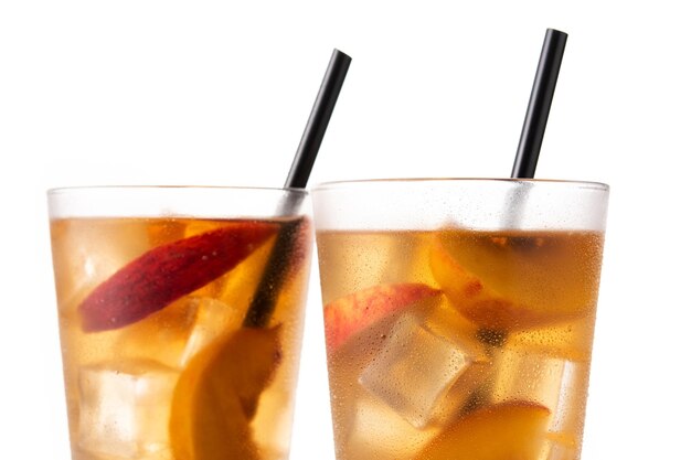 Glass of peach tea with ice cubes isolated on white background