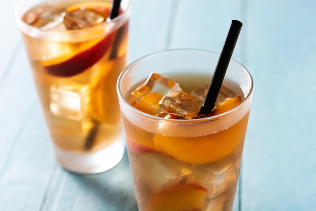 Glass of peach tea with ice cubes