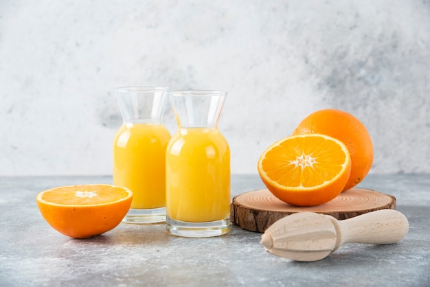 Glass pitchers of juice with slice of orange fruit .