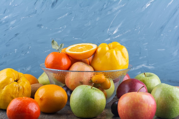 Glass plate of fresh fruits on top of many fruits.