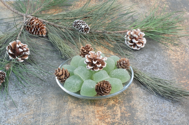 Free photo a glass plate of green marmalade and pinecones. high quality photo