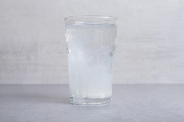 A glass of pure cold water on gray background. 