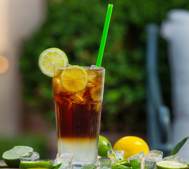 A glass of red cocktail mojito with slice of lemon, lime on a restaurant background - Image