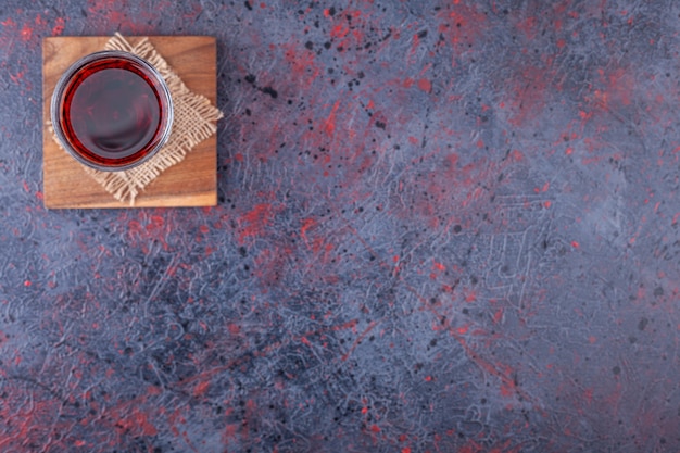 Free Photo glass of red cocktail with fruit slices on marble.