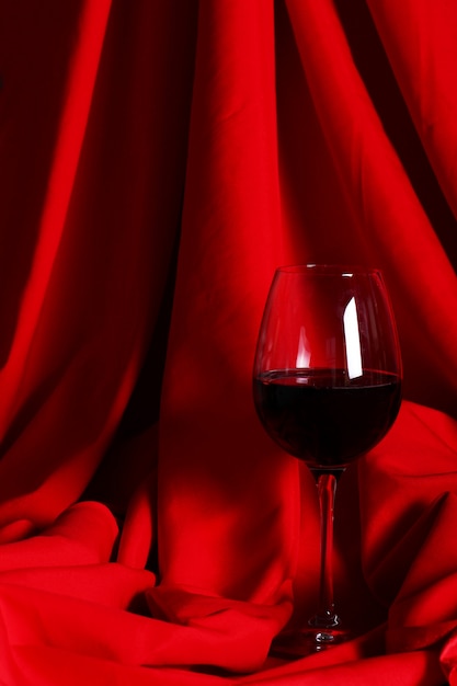 Free photo glass of red wine on red cloth