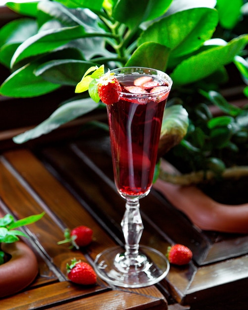 Free photo a glass of strawberry cocktail garnished with strawberry