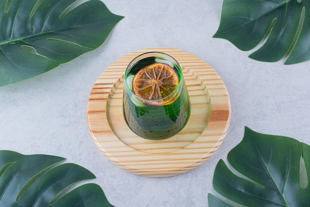 Glass of tarragon juice on wooden plate. High quality photo