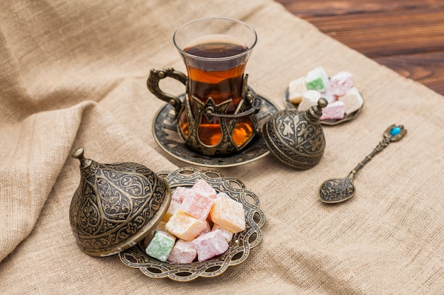 Glass of tea with Turkish delight on canvas