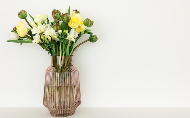 Glass vase with flowers in the interior of the room